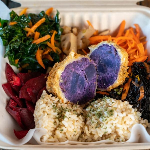 A healthy Kaimana Farm Cafe plate with purple sweet potato croquettes, brown rice, beets, and greens.
