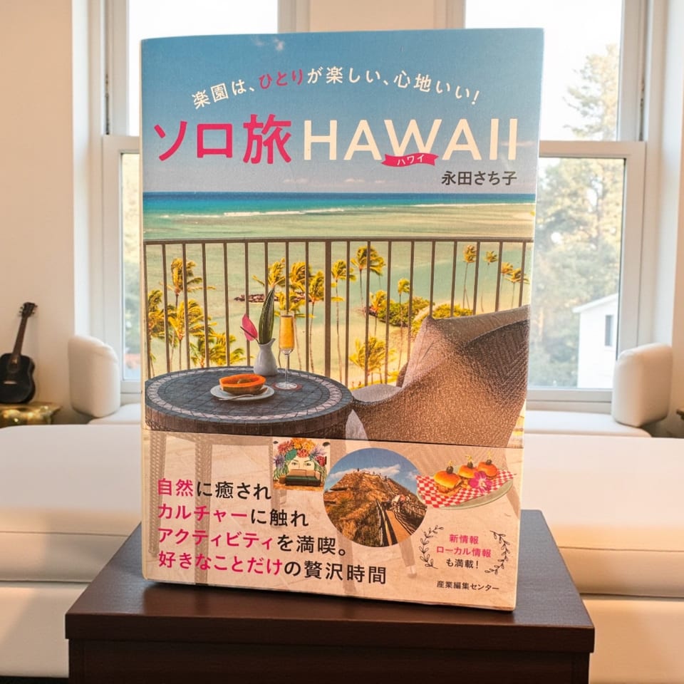 A Japanese travel guide to Hawaii, featuring a balcony view of the ocean and palm trees.